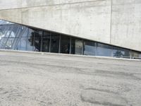 the rear end of a building that's being used for skateboarding riding, with a window on one of the sides