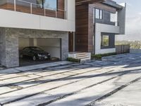 the exterior and landscape of a modern house in los angeles, california with stone and wood