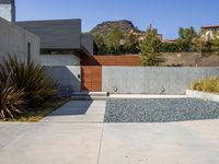 a gray concrete building with stairs and door at the top of the floor next to it is steps leading down to the doorway