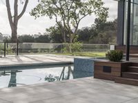 a small pool next to the outdoor living area of a house with a wooden fence