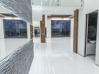 a public bathroom with glass doors and tiled flooring on the walls and floor leading to the toilet