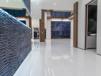 a public bathroom with glass doors and tiled flooring on the walls and floor leading to the toilet