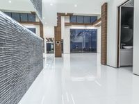 a public bathroom with glass doors and tiled flooring on the walls and floor leading to the toilet