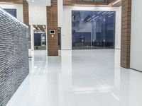 a public bathroom with glass doors and tiled flooring on the walls and floor leading to the toilet