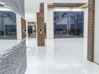 a public bathroom with glass doors and tiled flooring on the walls and floor leading to the toilet