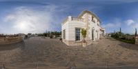 a fisheye photograph of the entrance way and back yard area of a mansion with a patio