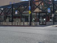 a building on the corner with parking spaces across it and a street sign on the sidewalk