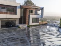 the view from the top of the hill of a residence with driveway leading into the house