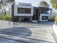 the exterior and landscape of a modern house in los angeles, california with stone and wood