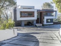 the exterior and landscape of a modern house in los angeles, california with stone and wood