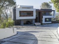 the exterior and landscape of a modern house in los angeles, california with stone and wood