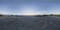 a panoramic view of a mountain road from behind it is seen through a curved lens