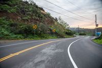 two lane road curves in the mountains and is shown in blurry photograph while driving