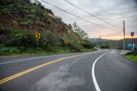 two lane road curves in the mountains and is shown in blurry photograph while driving