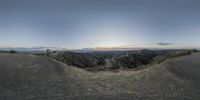 a panoramic view of a mountain with some dirt on the ground and a sky background