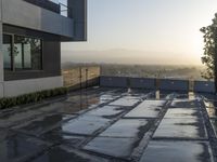 an outdoor patio overlooking the mountains with water running on it and some concrete slabs underneath