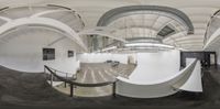 this view is 360 - view of a hallway in a museum or art gallery with curved curved walls and arches