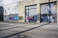 a person rides a skateboard near graffiti covered buildings along the street in a city