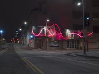 street lights illuminate the exterior of a modern building at night with a neon sign for an electrical station