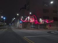 street lights illuminate the exterior of a modern building at night with a neon sign for an electrical station