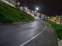 a picture of the night time in a city area with a road and tall buildings