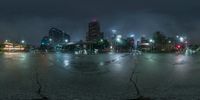 a city street at night with the traffic light on and dark clouds overhead in the distance