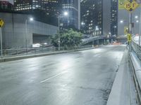 an empty city street during the night with no traffic and many lights on it,