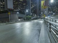 an empty city street during the night with no traffic and many lights on it,