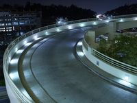 the curve of a freeway with traffic on it's sides in the dark night sky