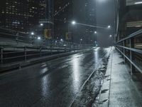 a very dark city street with a bridge near it and some cars at night as if on the road