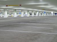 a garage with some cars parked inside it and the floor is empty while the parking lots have painted white