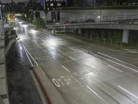 a highway in the rain on an overpass during the night time, with street signs warning motorists to stop