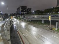 a highway in the rain on an overpass during the night time, with street signs warning motorists to stop