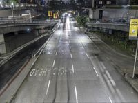 a highway in the rain on an overpass during the night time, with street signs warning motorists to stop