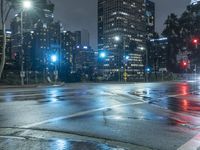 a city street filled with traffic lights and tall buildings at night - time on a rainy night