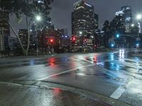 a city street filled with traffic lights and tall buildings at night - time on a rainy night