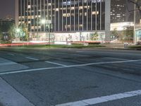 the city at night is filled with tall buildings and traffic lights on both sides of the street