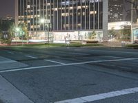 the city at night is filled with tall buildings and traffic lights on both sides of the street