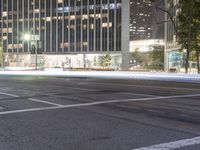 the city at night is filled with tall buildings and traffic lights on both sides of the street