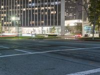 the city at night is filled with tall buildings and traffic lights on both sides of the street