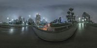 city lights on a street at night with a curved mirror of the road below it