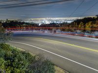 a night shot of a city from the top of a hill with long exposures of light streaks