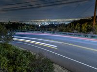 a night shot of a city from the top of a hill with long exposures of light streaks