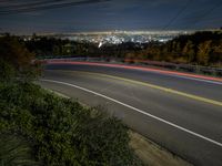 a night shot of a city from the top of a hill with long exposures of light streaks