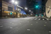 the street is empty in a city at dusk with some traffic lights on and tall buildings