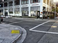 an intersection has a traffic light and a red stop sign on the corner of it