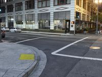 an intersection has a traffic light and a red stop sign on the corner of it