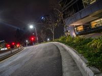 an empty street with two red lights at the corner of it and many tall buildings