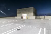 a parking lot with an empty parking lot at night with its doors open, near a building with lights on it