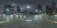 street with cars and skyscrapers at night near cityscape in nighttime time taken with fish eye lens